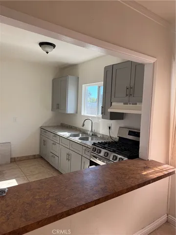 a kitchen with stainless steel appliances granite countertop a sink stove and cabinets