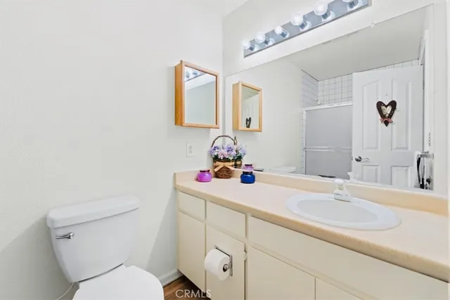 a bathroom with a sink vanity granite and toilet