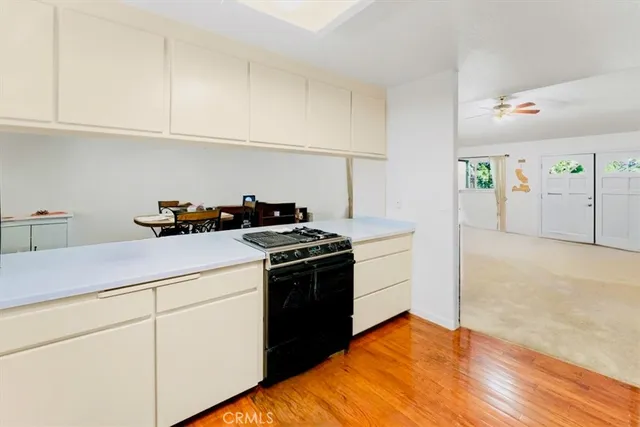a kitchen with a stove cabinets and wooden floor