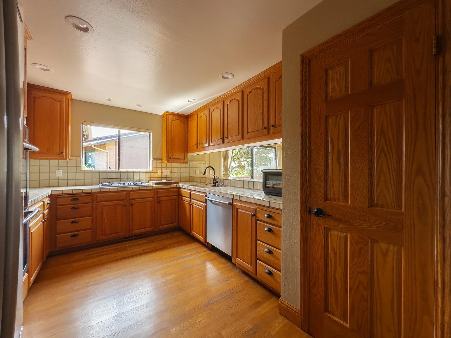 14170 Reservation Road Salinas, CA 93908 - Photo 13 of 22 a kitchen with granite countertop wooden cabinets stainless steel appliances a sink and a window