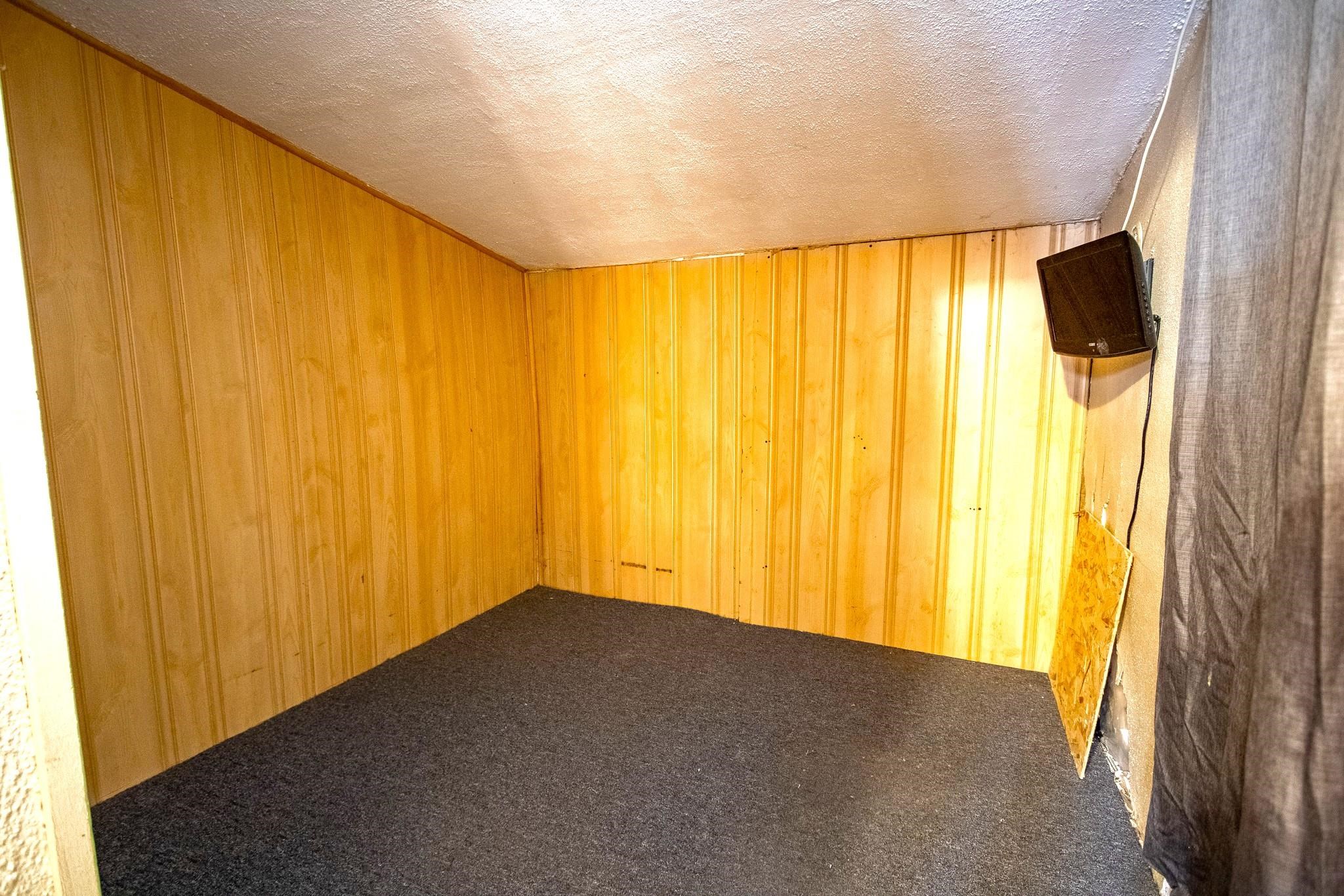 3946 East Calvary Road Duluth, MN 55803 - Photo 9 of 12 Carpeted empty room featuring a textured ceiling and wooden walls