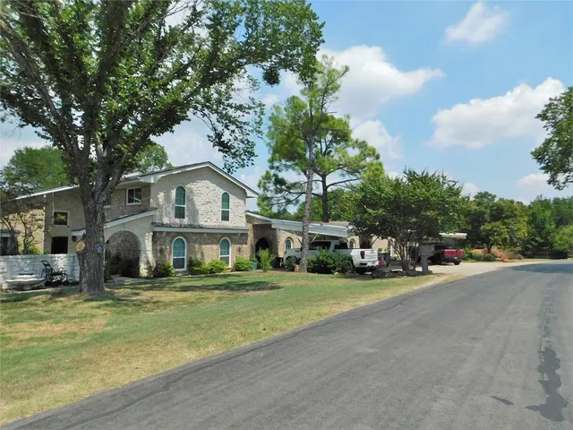 a front view of a house with a garden and trees