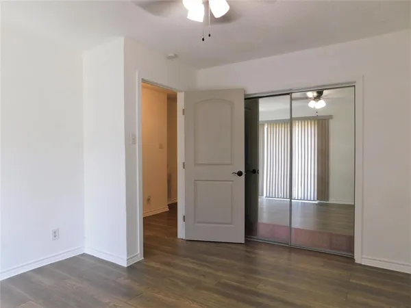 an empty room with wooden floor and mirror