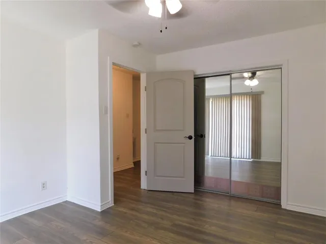an empty room with wooden floor and mirror
