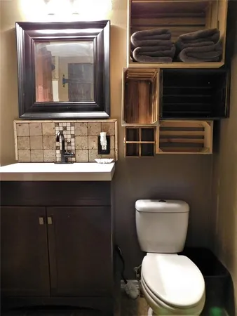a bathroom with a toilet a sink and mirror