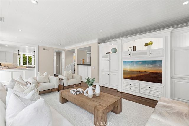 a kitchen with a stove a sink a center island and wooden floor