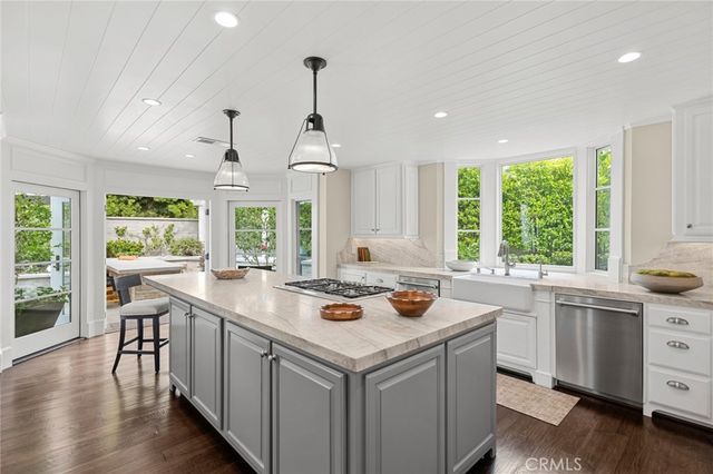 a kitchen that has a lot of cabinets in it and wooden floors