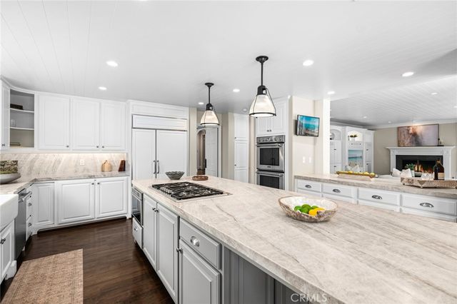 a open kitchen with stainless steel appliances kitchen island a stove and a wooden floors
