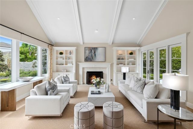 a living room with furniture fireplace and a large window