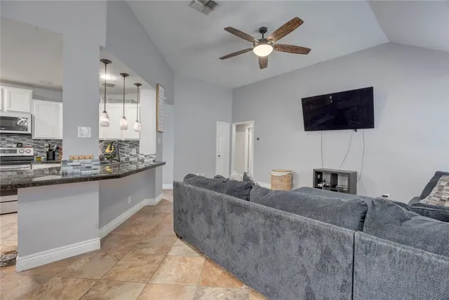 a living room with furniture a fireplace and a flat screen tv