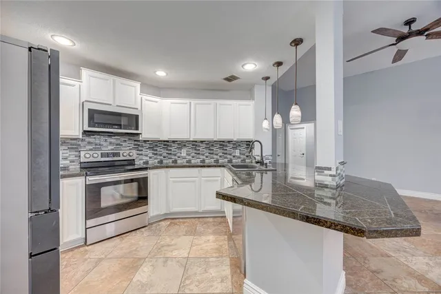 a kitchen with kitchen island granite countertop a stove sink and microwave