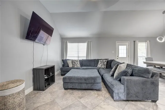 a living room with furniture a flat screen tv and a window