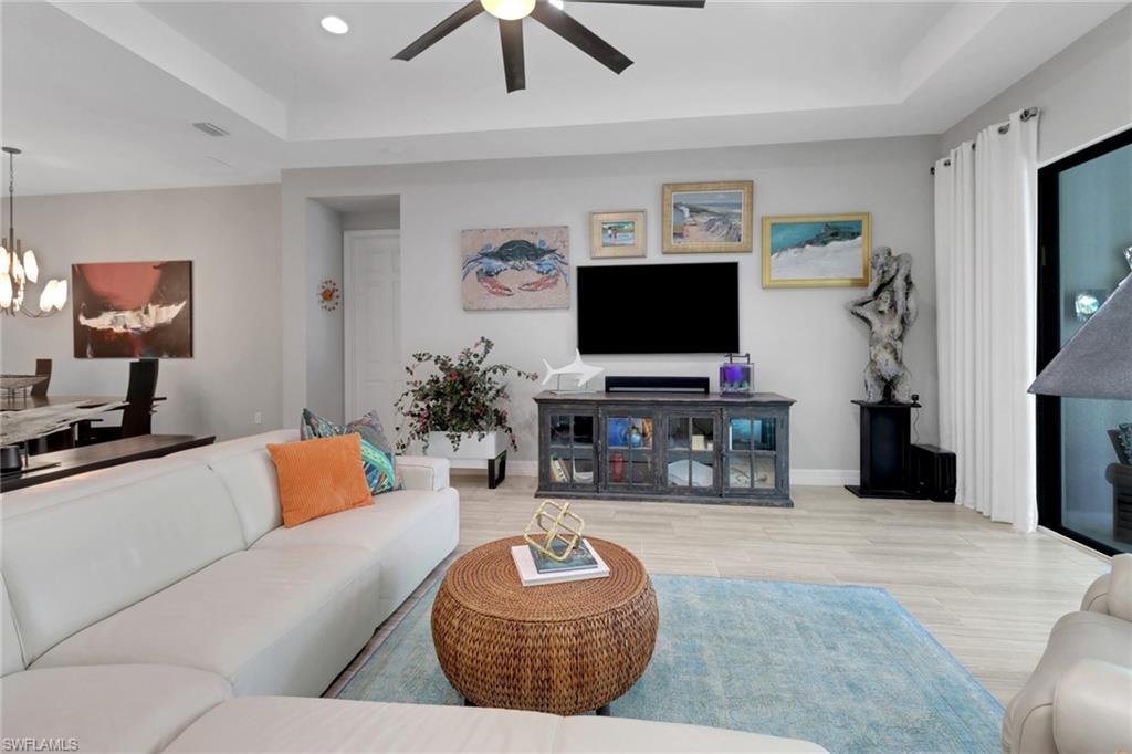 13836 Luna Drive Naples, FL 34109 - Photo 12 of 36 a living room with furniture and a flat screen tv with wooden floor