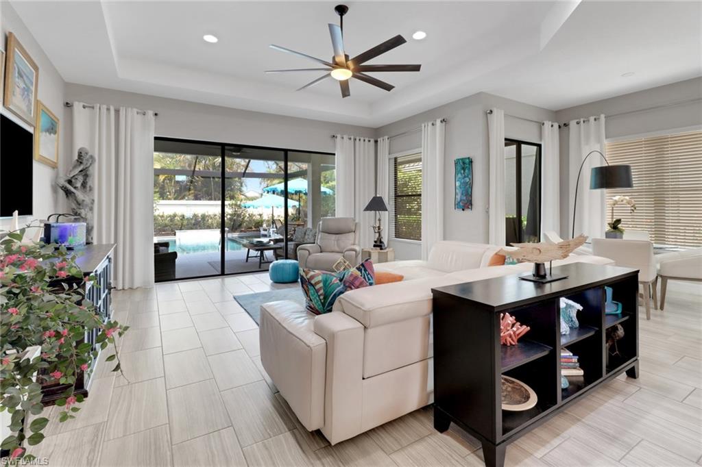 13836 Luna Drive Naples, FL 34109 - Photo 14 of 36 a living room with furniture a large window and a chandelier