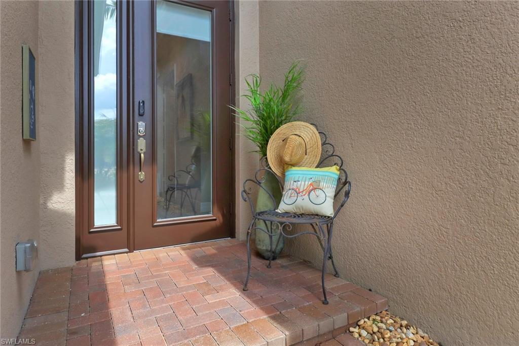 13836 Luna Drive Naples, FL 34109 - Photo 3 of 36 a view of a hallway that has painting on the table and a potted plant