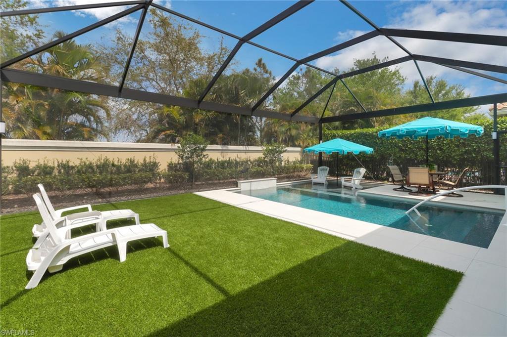 13836 Luna Drive Naples, FL 34109 - Photo 31 of 36 a view of backyard with table and chairs under an umbrella