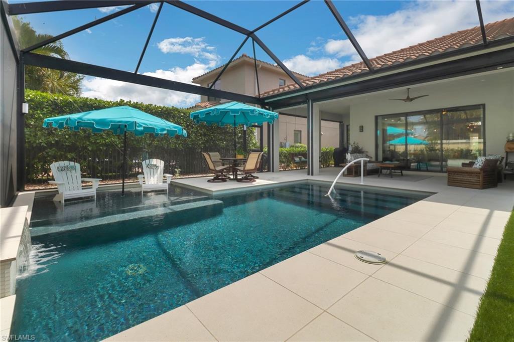 13836 Luna Drive Naples, FL 34109 - Photo 32 of 36 a view of patio with table and chairs under an umbrella