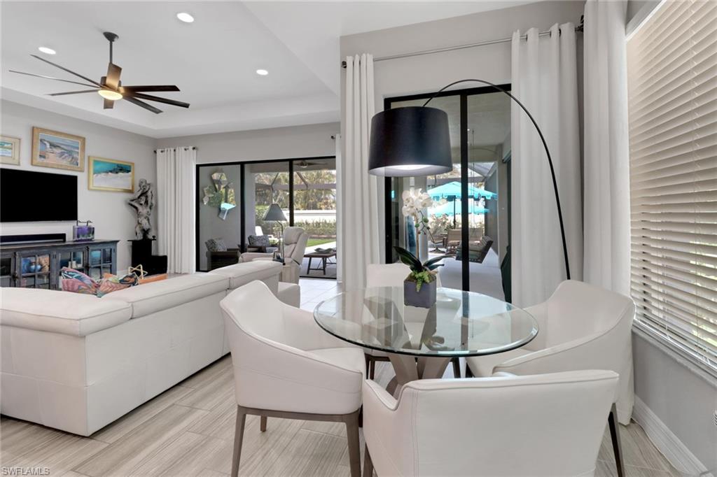 13836 Luna Drive Naples, FL 34109 - Photo 7 of 36 a living room with furniture a flat screen tv and floor to ceiling window