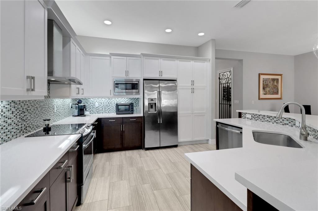 13836 Luna Drive Naples, FL 34109 - Photo 10 of 36 a kitchen with a sink a stove a refrigerator and a refrigerator