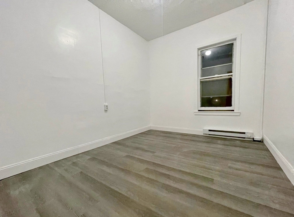 28 Randall Place Springfield, MA 01108 - Photo 22 of 22 an empty room with a window and wooden floor