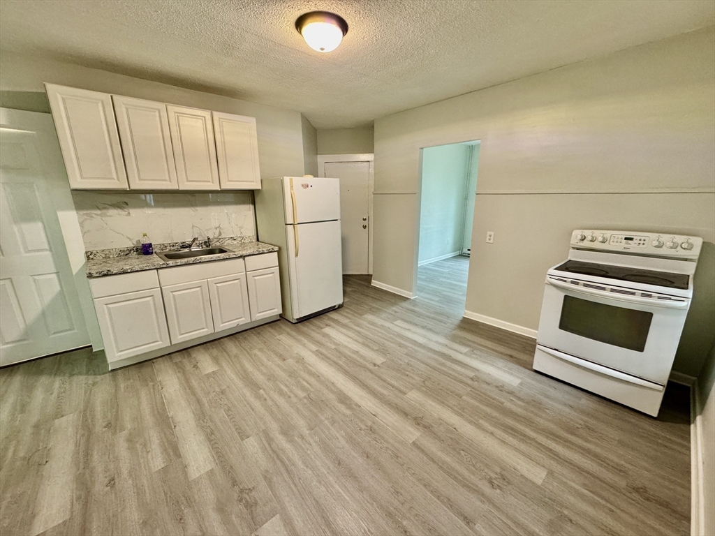 28 Randall Place Springfield, MA 01108 - Photo 5 of 22 a kitchen with white cabinets and white appliances