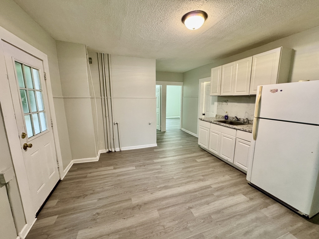 28 Randall Place Springfield, MA 01108 - Photo 6 of 22 a kitchen with a refrigerator a stove top oven and a refrigerator