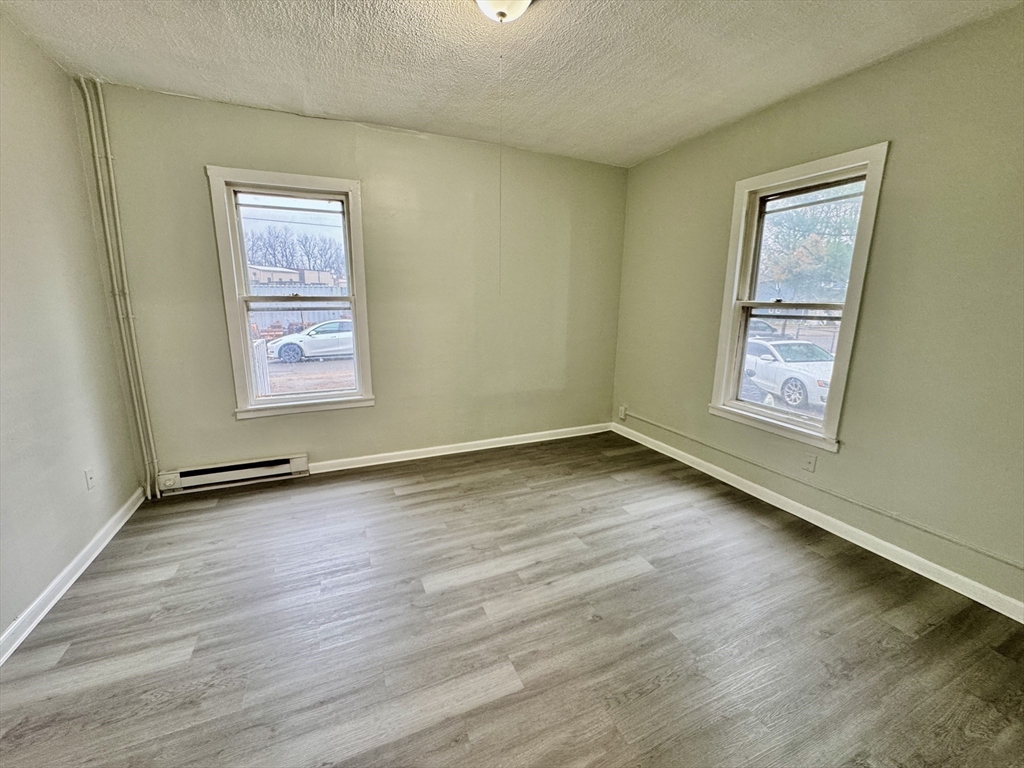 28 Randall Place Springfield, MA 01108 - Photo 7 of 22 a view of an empty room with a window and wooden floor