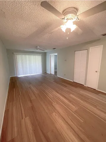 a view of a livingroom with a chandelier fan and windows