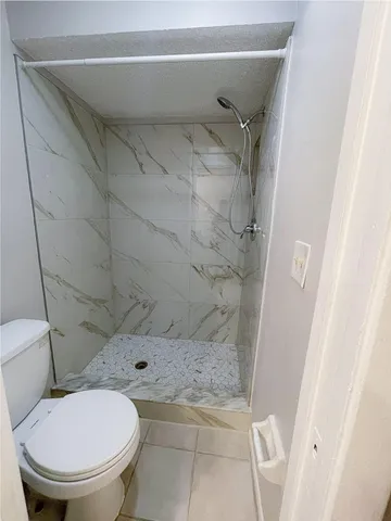 a bathroom with a toilet and a shower