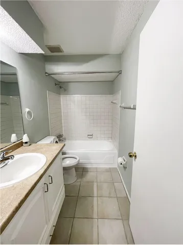 a spacious bathroom with a granite countertop sink a toilet and shower