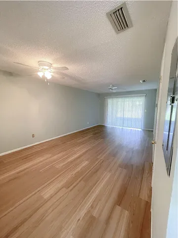 a view of empty room with wooden floor