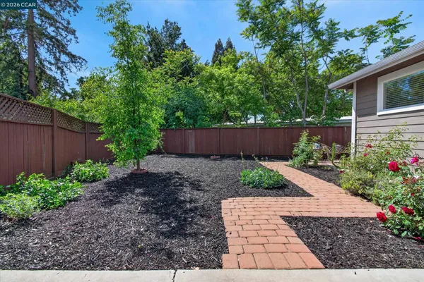 a front view of a house with a yard and potted plants