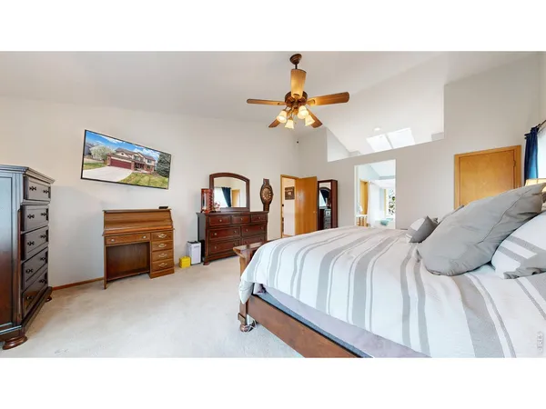 a bedroom with a bed a dresser and a chandelier