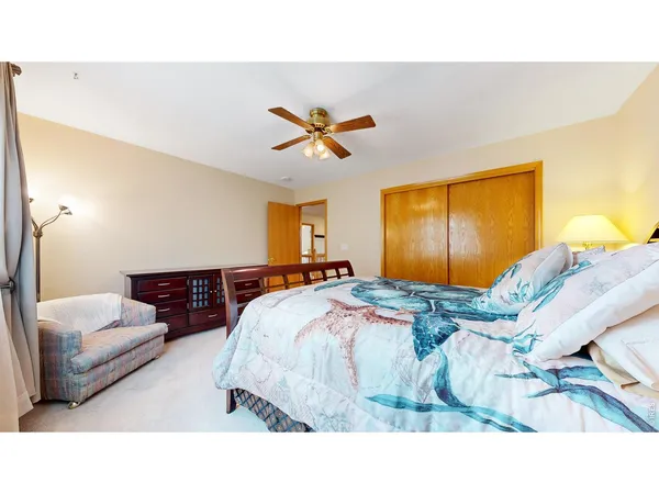 a bedroom with a bed and a ceiling fan