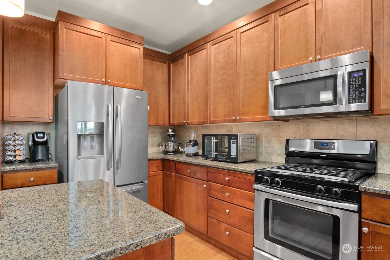 4806 Northeast 3rd Place Renton, WA 98059 - Photo 8 of 32 a kitchen with stainless steel appliances granite countertop a stove microwave refrigerator and sink