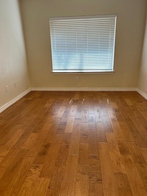 3102 Kings Road, Unit 3208 Dallas, TX 75219 - Photo 4 of 6 an empty room with wooden floor and windows