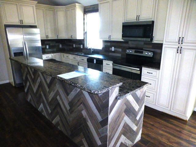 314 North Dubellette Street Weatherford, TX 76086 - Photo 6 of 17 a kitchen with stainless steel appliances granite countertop a stove a sink and a microwave