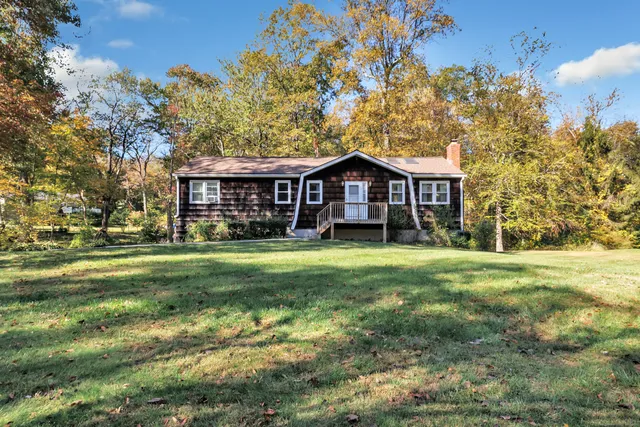 a front view of a house with a yard table and chairs