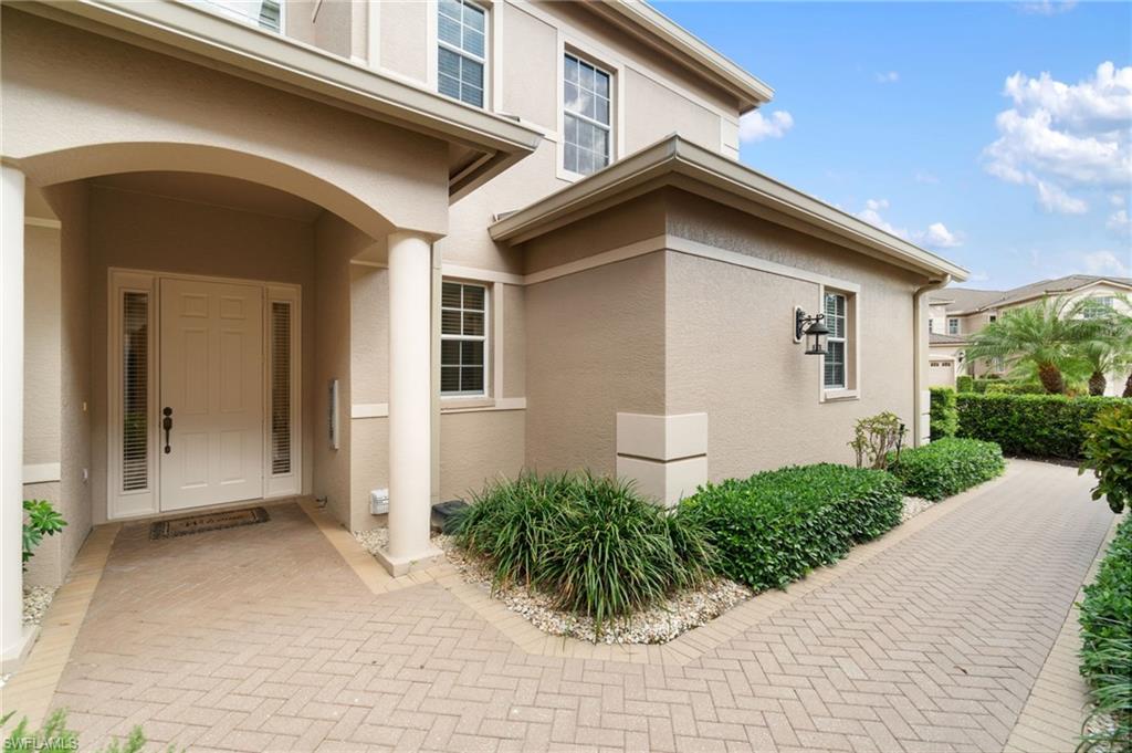 734 Regency Reserve Circle, Unit 2702 Naples, FL 34119 - Photo 3 of 48 a front view of a house with garden