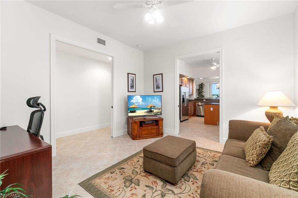 734 Regency Reserve Circle, Unit 2702 Naples, FL 34119 - Photo 9 of 48 a living room with furniture and a lamp