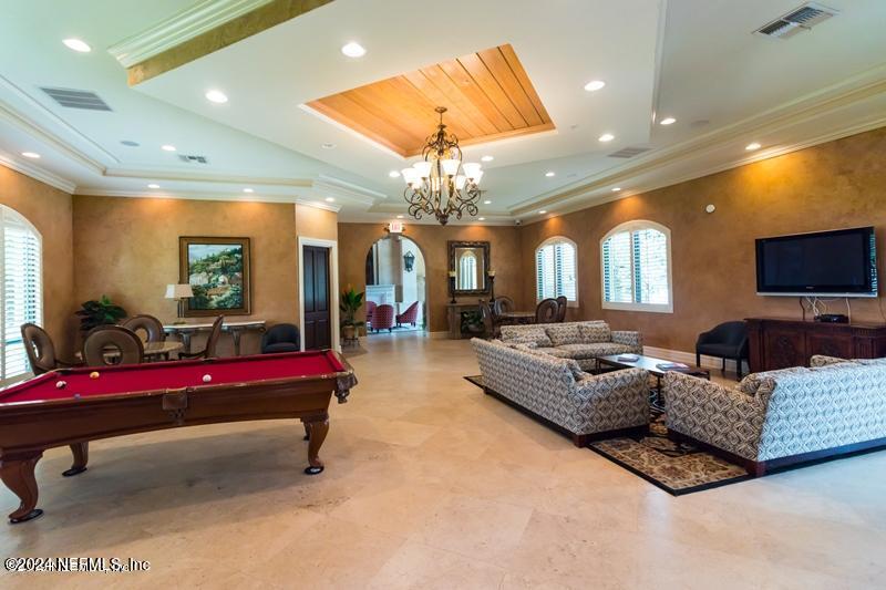 9745 Touchton Road, Unit 1805 Jacksonville, FL 32246 - Photo 16 of 77 a living room with furniture a chandelier and a flat screen tv