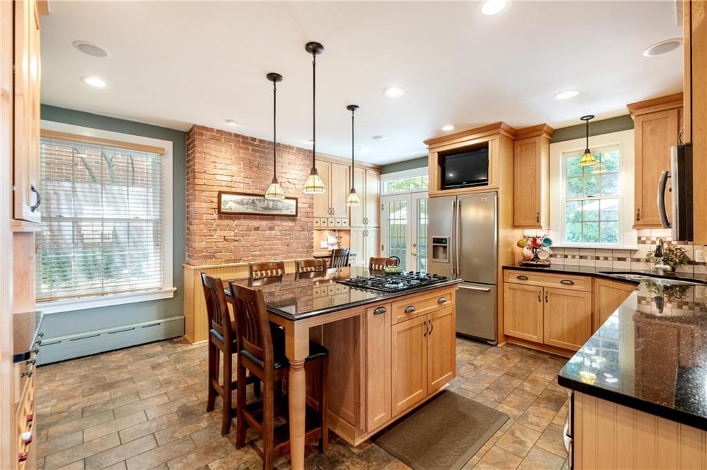 4375 Schenley Farms Terrace Pittsburgh, PA 15213 - Photo 14 of 44 a kitchen with stainless steel appliances granite countertop a stove top oven a sink dishwasher a dining table and chairs with wooden floor