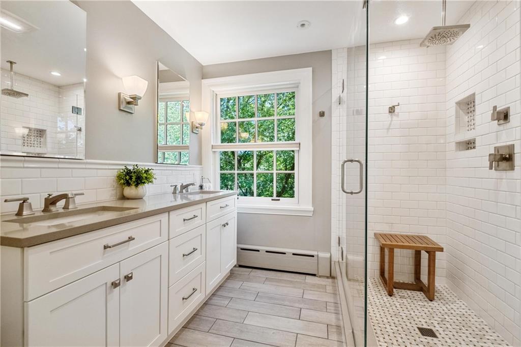 4375 Schenley Farms Terrace Pittsburgh, PA 15213 - Photo 24 of 44 a spacious bathroom with a double vanity sink a large mirror a shower and a bathtub