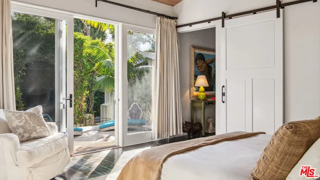 a bedroom with a bed and a couch next to a window