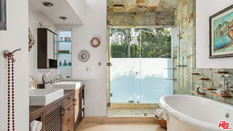 a bathroom with a tub sink and mirror