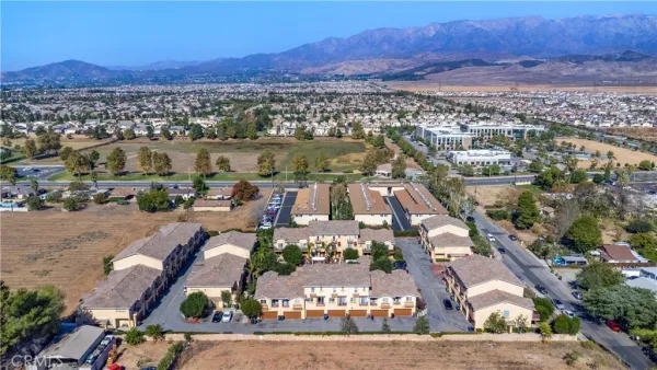 an aerial view of a city with lots of residential buildings and mountain view in back