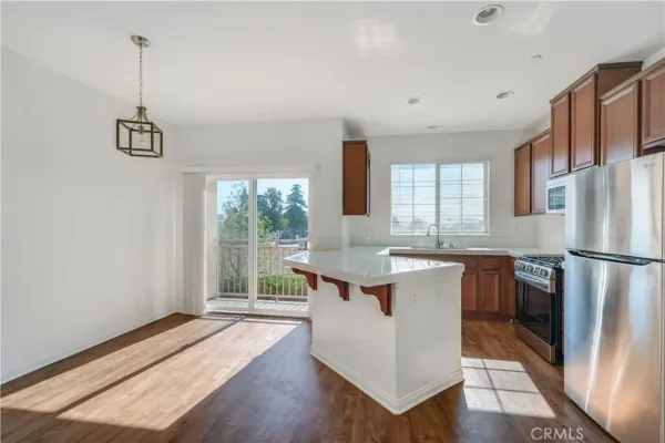 a kitchen with a refrigerator a sink and dishwasher with wooden floor