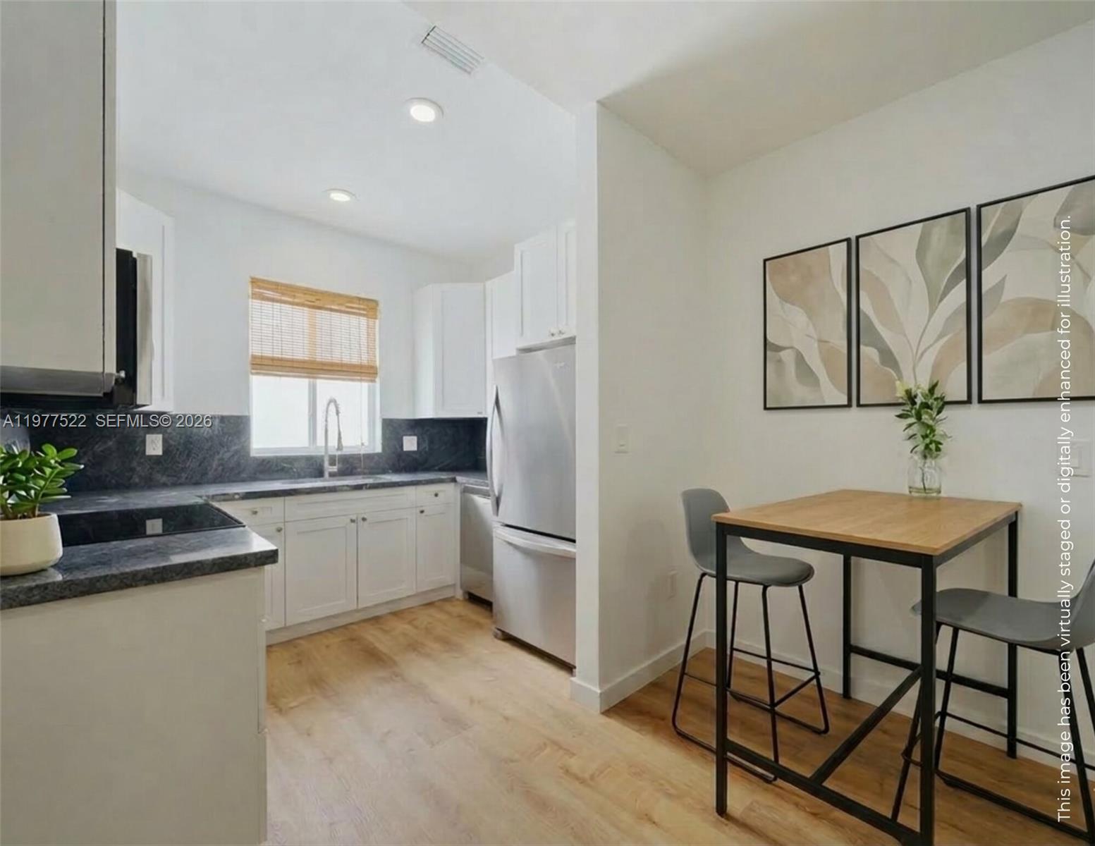 2976 Bird Avenue, Unit 18 Miami, FL 33133 - Photo 6 of 11 a kitchen with stainless steel appliances granite countertop a refrigerator a stove a sink and white cabinets with wooden floor