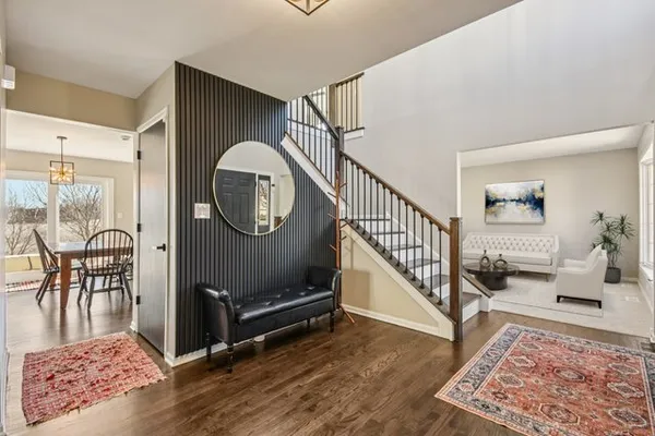 a view of a hallway with wooden floor windows and a rug