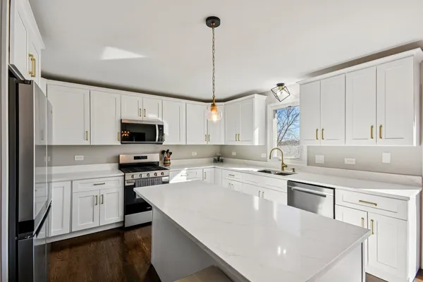a kitchen with appliances a sink and cabinets